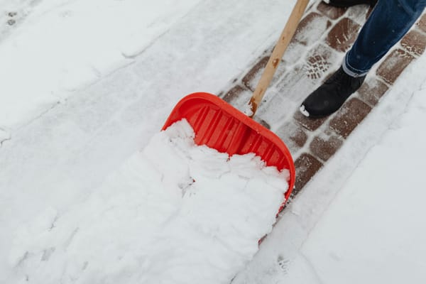 Arbeiter schaufelt schnee weg